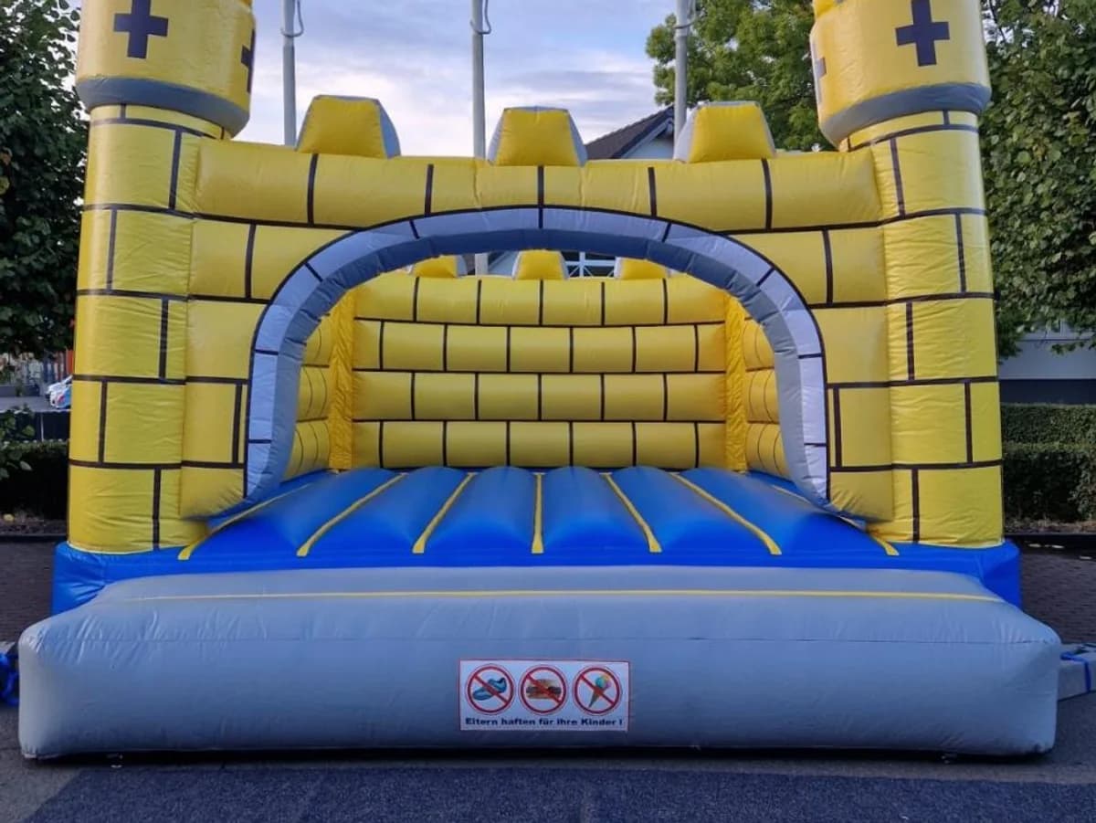 Gelbe Ritterburg mit grauen Zinnen und blauer Sprungfläche
